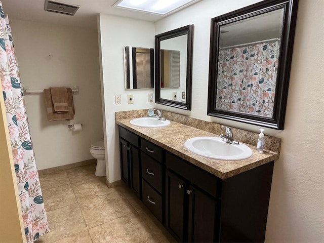 bathroom featuring tile patterned flooring, vanity, and toilet