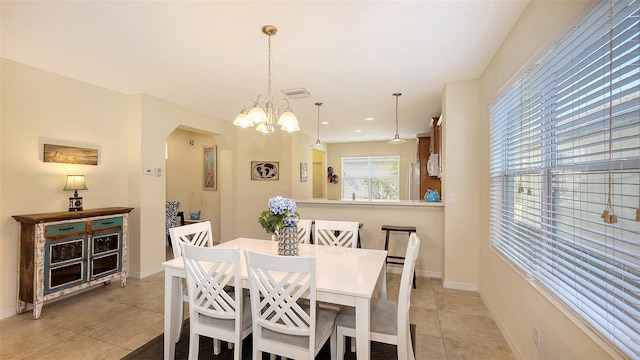 dining room with light tile patterned flooring and a chandelier