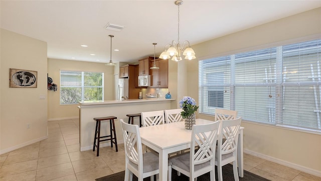 dining room featuring a notable chandelier and light tile patterned flooring