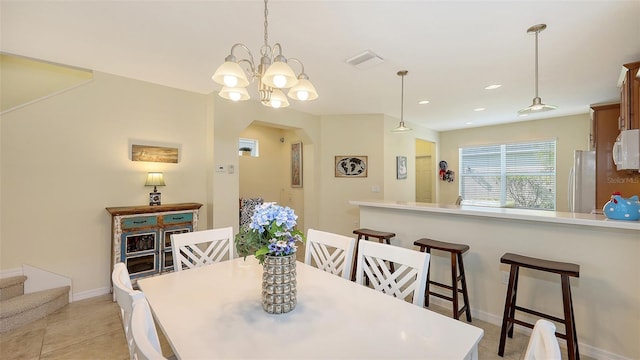 tiled dining room with a notable chandelier