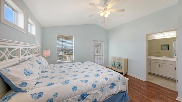 bedroom featuring dark wood-type flooring, ensuite bath, lofted ceiling, ceiling fan, and sink