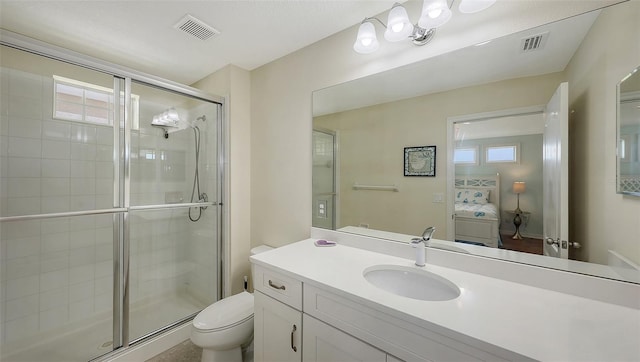 bathroom featuring toilet, vanity, and a shower with shower door