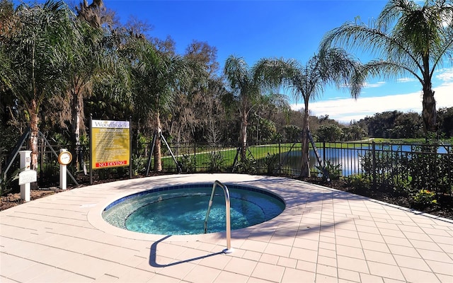 view of swimming pool with a hot tub and a water view