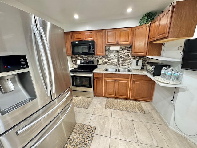 kitchen featuring decorative backsplash, light stone countertops, stainless steel appliances, sink, and light tile patterned floors