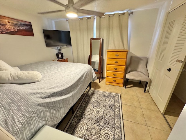 bedroom featuring ceiling fan, a closet, and light tile patterned flooring