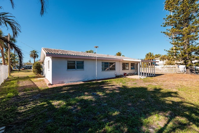 rear view of house featuring a yard