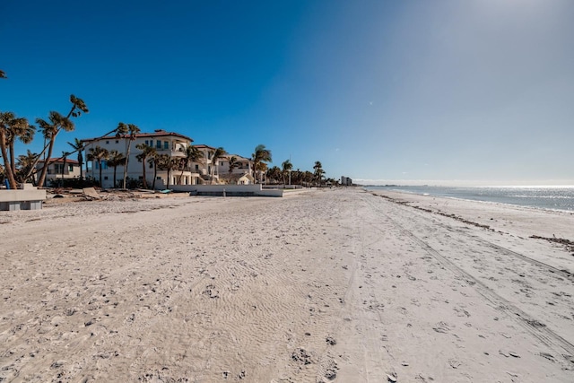 exterior space with a water view and a beach view