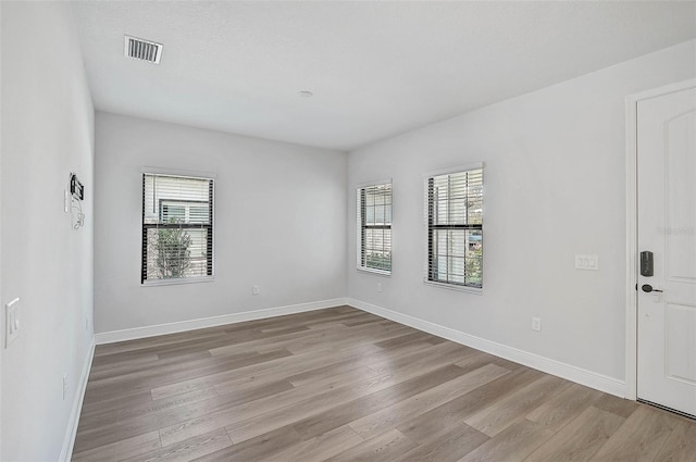 unfurnished room with light hardwood / wood-style flooring and a healthy amount of sunlight