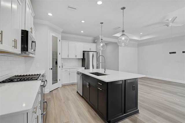 kitchen featuring white cabinetry, a center island with sink, stainless steel appliances, and sink