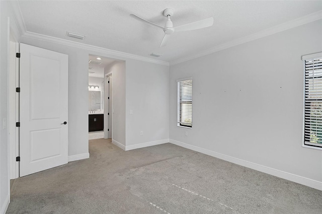 spare room with ceiling fan, ornamental molding, and light carpet