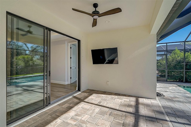 view of patio featuring ceiling fan and a lanai