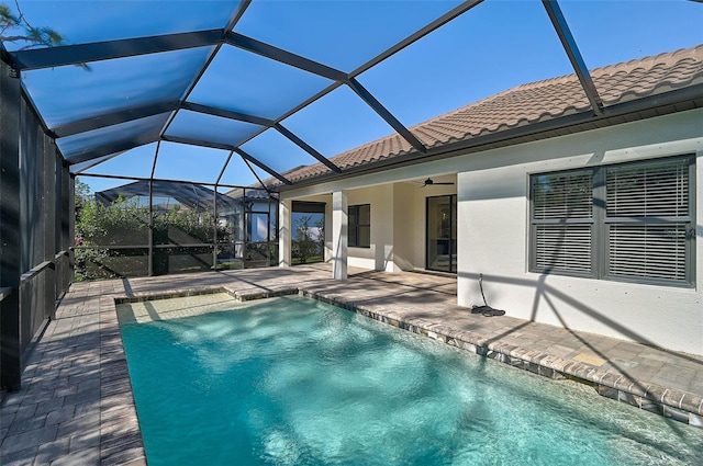 view of pool with a patio, ceiling fan, and a lanai