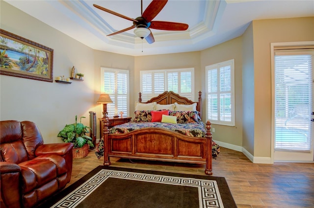 bedroom featuring a tray ceiling, ceiling fan, crown molding, and light hardwood / wood-style floors