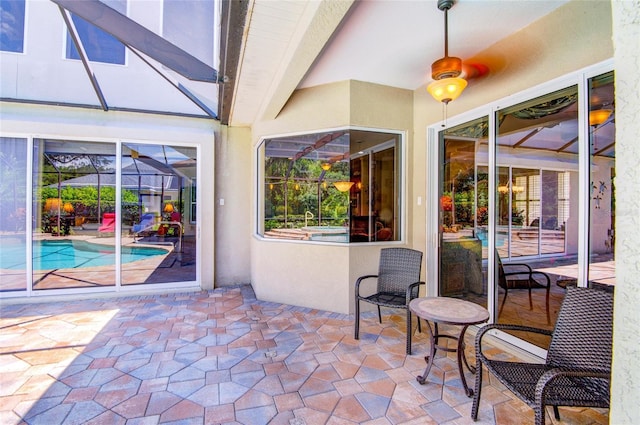 view of patio / terrace with ceiling fan and glass enclosure