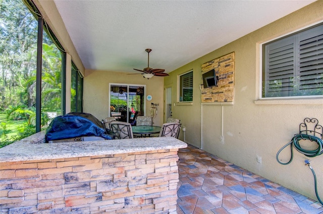 sunroom with ceiling fan and a healthy amount of sunlight