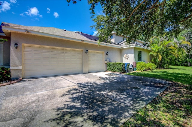 single story home featuring solar panels, a garage, and a front lawn