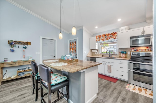 kitchen featuring a kitchen breakfast bar, white cabinetry, a center island, and stainless steel appliances