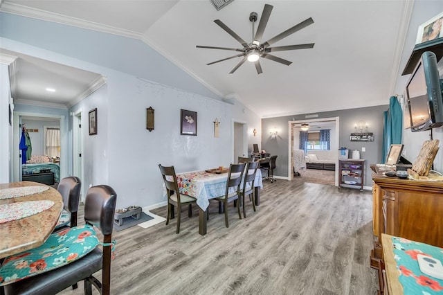 dining space with ceiling fan, light wood-type flooring, ornamental molding, and vaulted ceiling