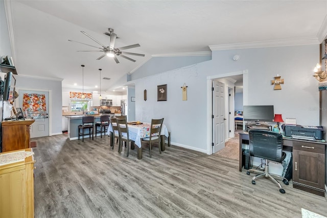 dining area featuring lofted ceiling, ceiling fan, wood-type flooring, and crown molding