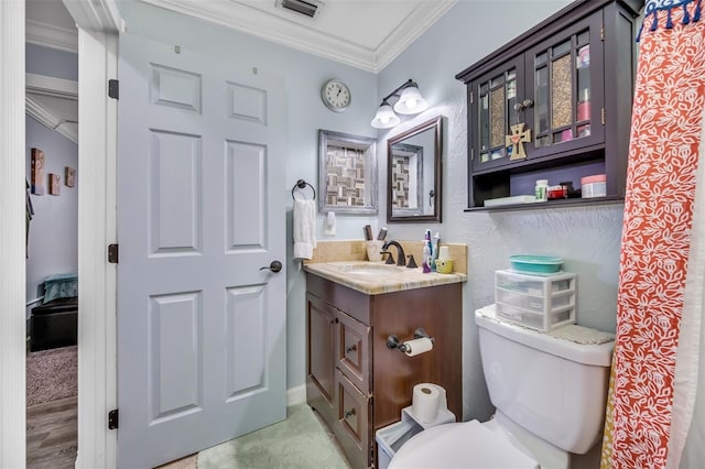 bathroom with vanity, toilet, and ornamental molding