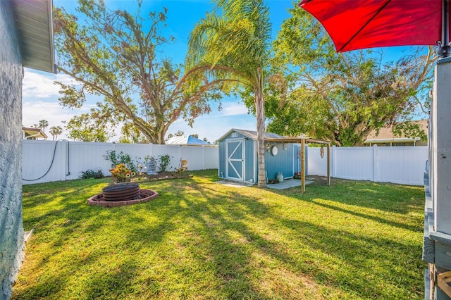 view of yard featuring an outdoor fire pit and a storage unit