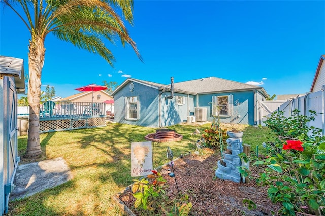 back of house with a wooden deck and a yard