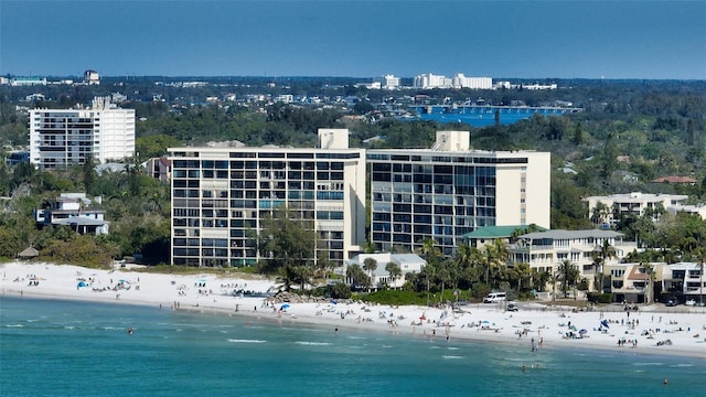 birds eye view of property with a water view and a beach view