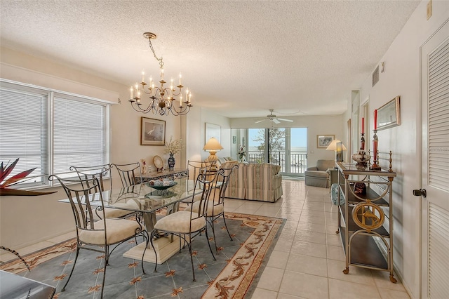 tiled dining space featuring a textured ceiling and ceiling fan with notable chandelier