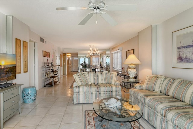 tiled living room with ceiling fan with notable chandelier