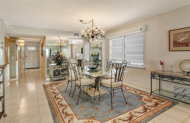 tiled dining area featuring a notable chandelier, a healthy amount of sunlight, and a textured ceiling