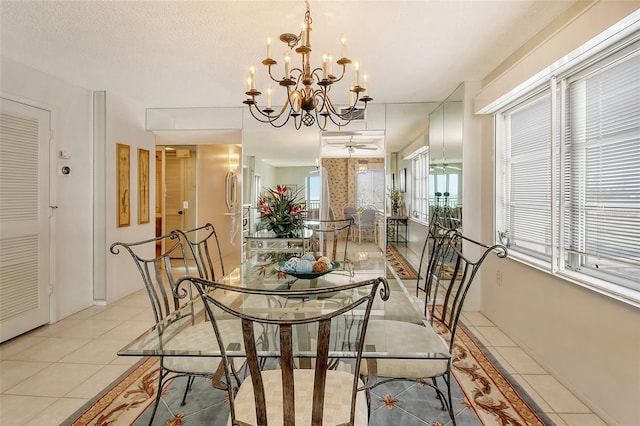 dining area with a textured ceiling, a notable chandelier, and light tile patterned flooring