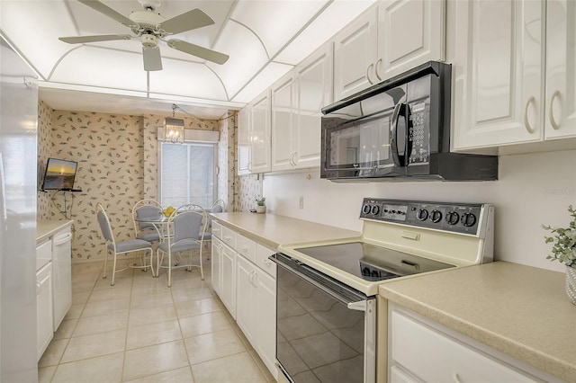 kitchen featuring range with electric stovetop, white cabinetry, light tile patterned flooring, and decorative light fixtures