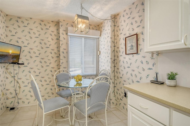 tiled dining area with a textured ceiling and a notable chandelier