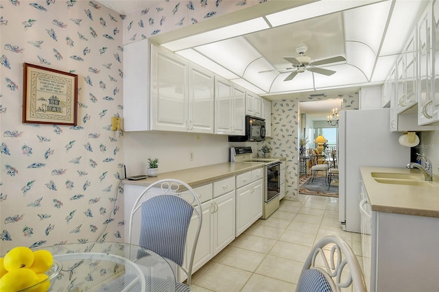 kitchen featuring ceiling fan with notable chandelier, sink, light tile patterned floors, electric range, and white cabinets