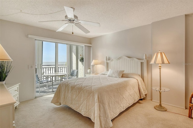 carpeted bedroom featuring access to exterior, a textured ceiling, and ceiling fan