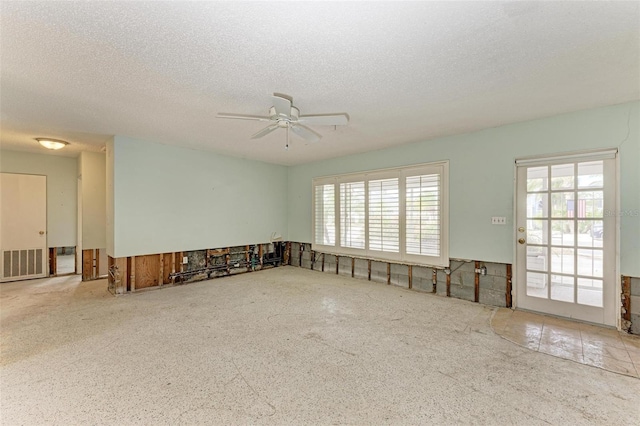 spare room with a textured ceiling and ceiling fan