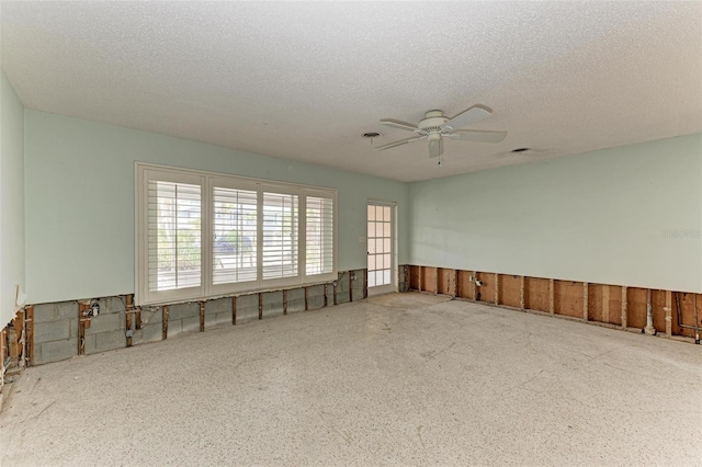 unfurnished room featuring ceiling fan and a textured ceiling