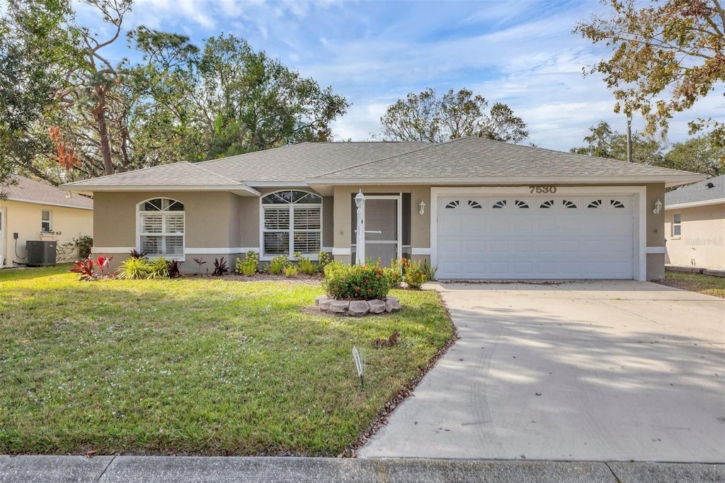 ranch-style house featuring cooling unit, a garage, and a front yard