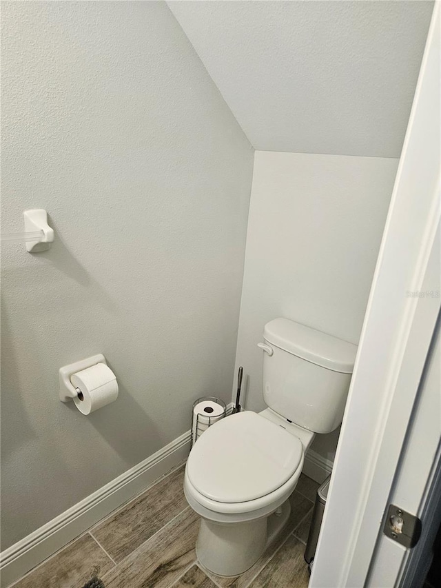 bathroom with lofted ceiling and toilet