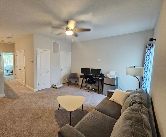 carpeted living room featuring a textured ceiling and ceiling fan