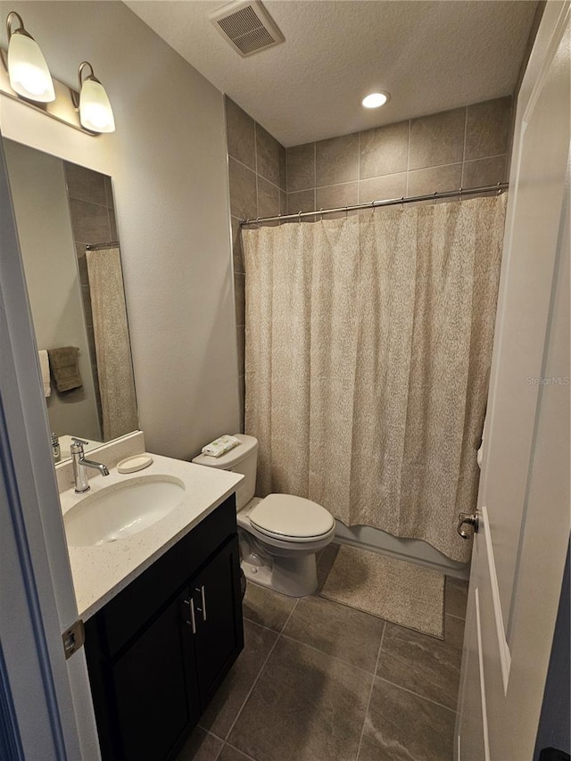 bathroom featuring a shower with curtain, vanity, a textured ceiling, and toilet