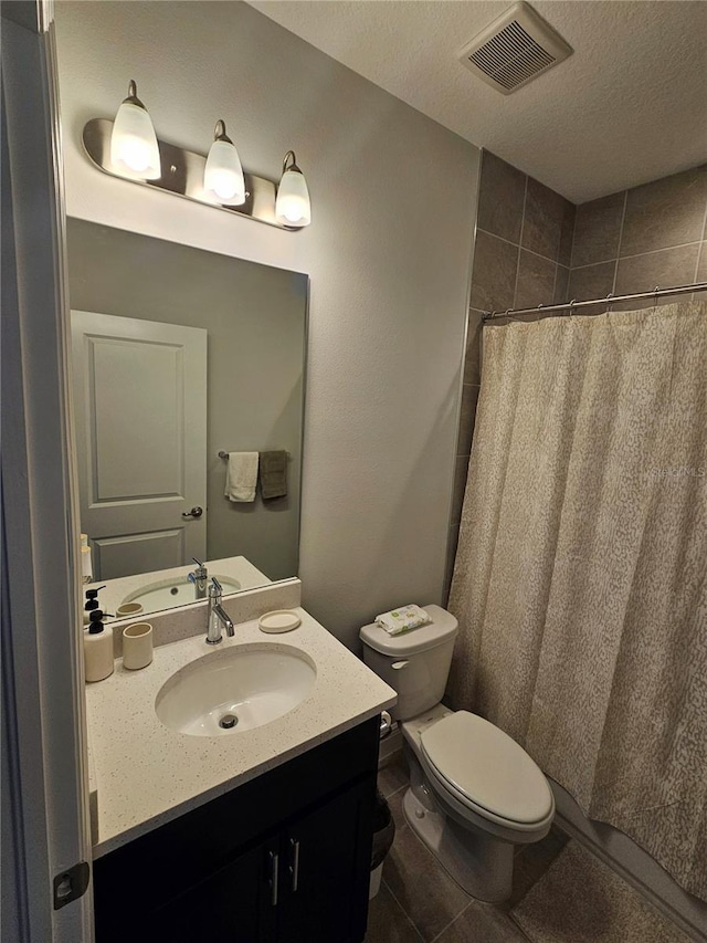 bathroom featuring tile patterned flooring, a textured ceiling, toilet, vanity, and a shower with shower curtain