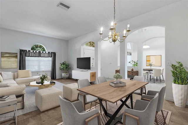 dining room with light carpet and an inviting chandelier