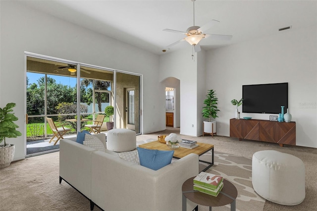 carpeted living room featuring a towering ceiling