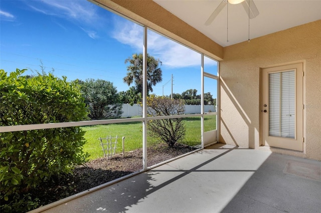 unfurnished sunroom featuring ceiling fan