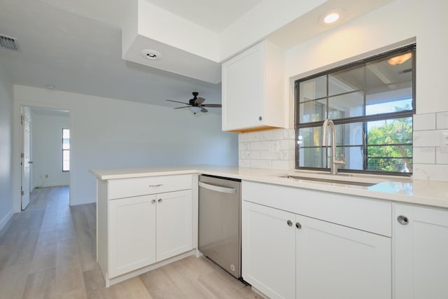 kitchen featuring stainless steel dishwasher, plenty of natural light, white cabinets, and kitchen peninsula