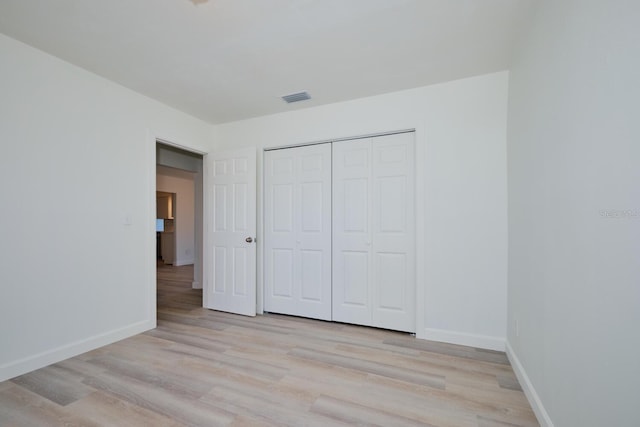 unfurnished bedroom with light hardwood / wood-style floors and a closet