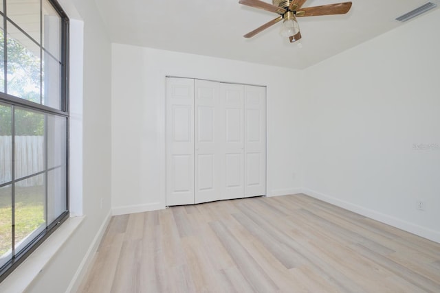 unfurnished bedroom with a closet, light hardwood / wood-style floors, and ceiling fan