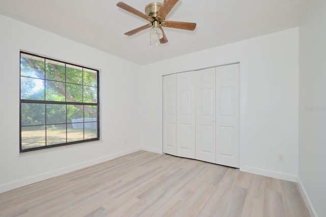 unfurnished bedroom with ceiling fan, a closet, and light hardwood / wood-style flooring