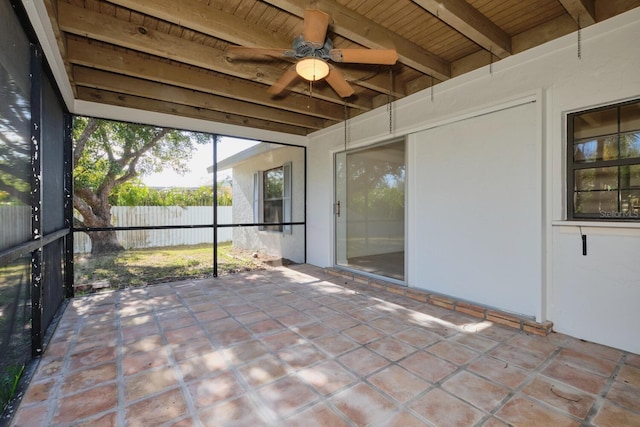 unfurnished sunroom featuring beamed ceiling, ceiling fan, and wood ceiling